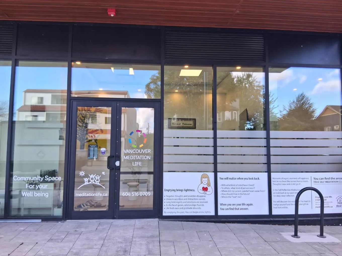 Storefront of Vancouver Meditation Life with glass doors, window decals and the centre logo
